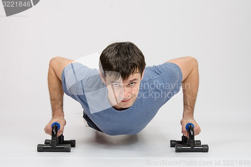 Image of The athlete performs a bench on supports