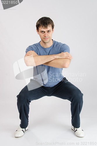 Image of young man performs squats