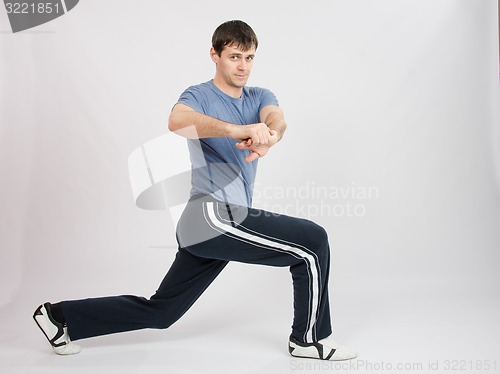 Image of Young man in sportswear warming up