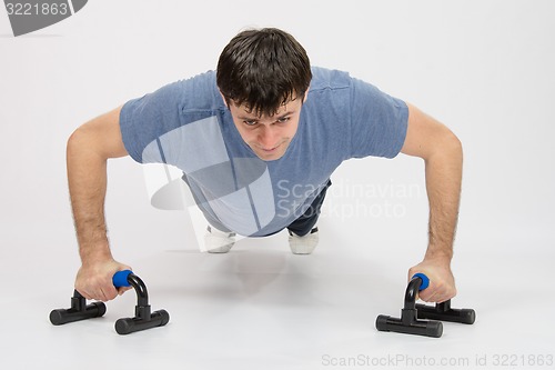 Image of Tired athlete is pushed on supports