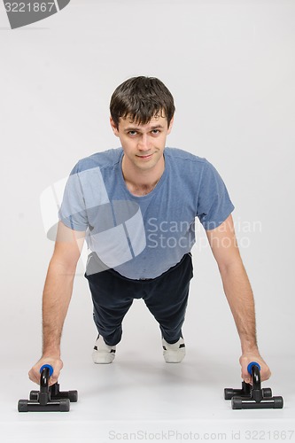 Image of Young guy pushed off the floor on legs