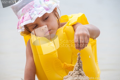 Image of Five-year girl builds a sand castle