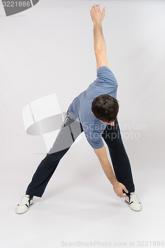 Image of Athletes perform Mahi hands reach for the left leg