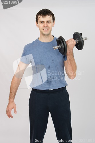 Image of Athlete dumbbell raises his left hand