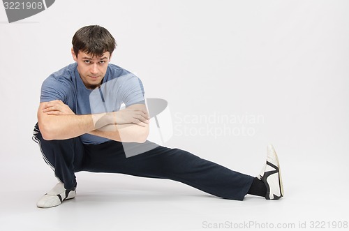 Image of Sportsman squatting muscles pulling the left foot