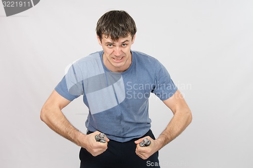 Image of Portrait of hard athlete with expander