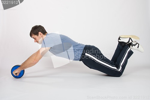 Image of Athletes perform push-ups with the wheel