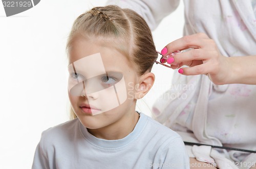 Image of Mom braids hair six-year daughter