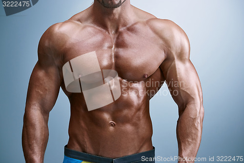 Image of Attractive male body builder on blue background