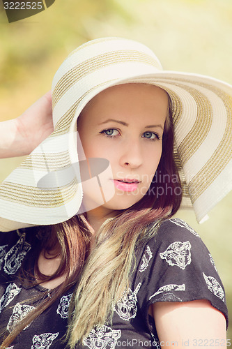 Image of Cheerful fashionable woman in stylish hat and frock posing