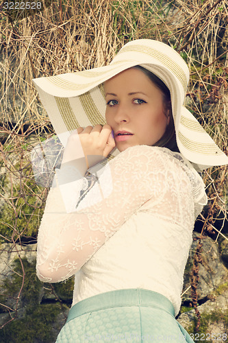 Image of Cheerful fashionable woman in stylish hat and frock posing