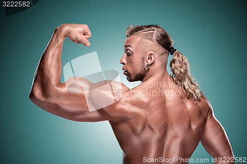 Image of Attractive male body builder on blue background