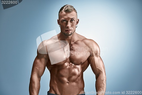 Image of Attractive male body builder on blue background