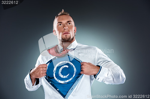 Image of businessman acting like a super hero and tearing his shirt off