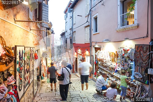 Image of Tourists walking next to displayed souvenirs in Rovinj