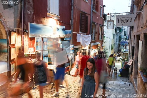 Image of People walking next to displayed souvenirs in Rovinj