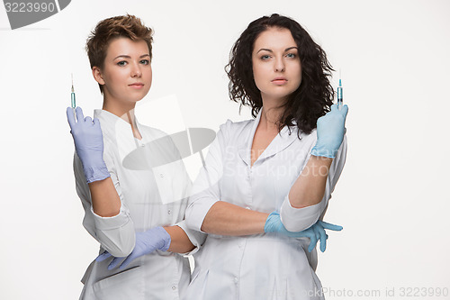 Image of Portrait of two women surgeons showing syringes 