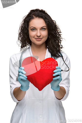 Image of Pretty woman doctor holding a red heart