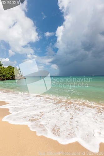 Image of Beach on tropical island. Clear blue water, sand, clouds. 