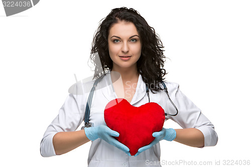 Image of Pretty woman doctor holding a red heart