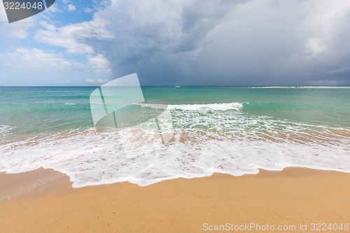 Image of Beach on tropical island. Clear blue water, sand, clouds. 