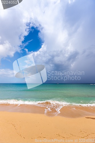 Image of Beach on tropical island. Clear blue water, sand, clouds. 