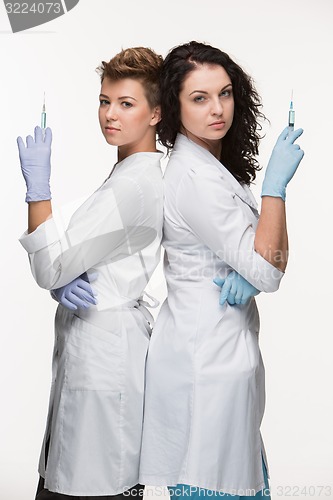 Image of Portrait of two women surgeons showing syringes 