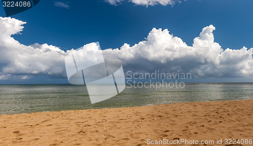 Image of Beach on tropical island. Clear blue water, sand, clouds. 