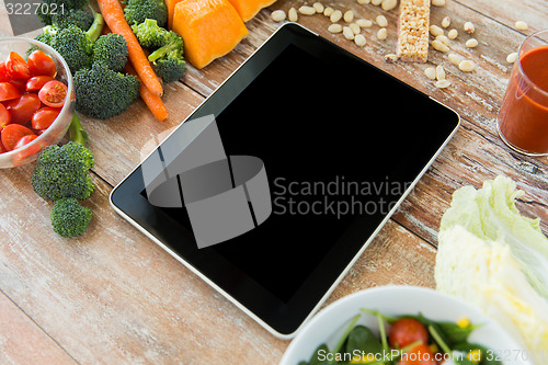 Image of close up of blank tablet pc screen and vegetables