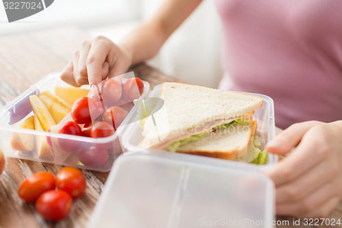 Image of close up of woman with food in plastic container