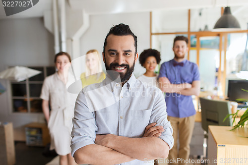 Image of happy young man over creative team in office