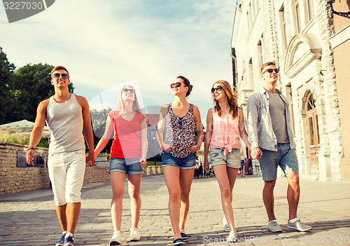 Image of group of smiling friends walking in city