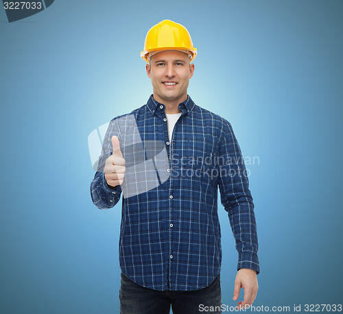 Image of smiling male builder in helmet showing thumbs up