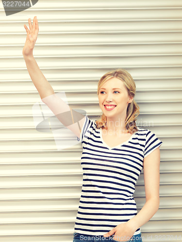 Image of happy teenage girl waving a greeting