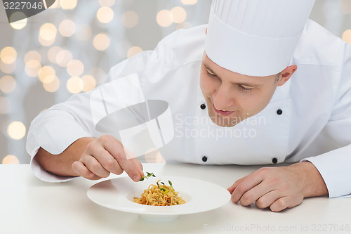 Image of happy male chef cook decorating dish