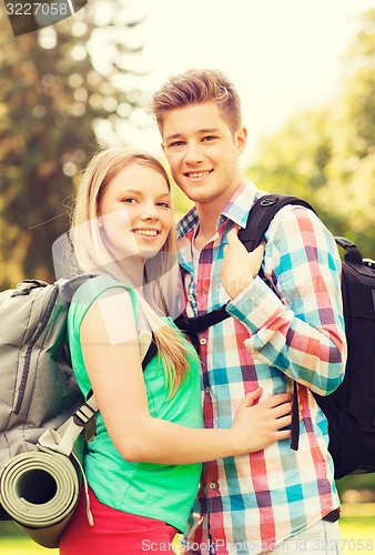 Image of smiling couple with backpacks in nature