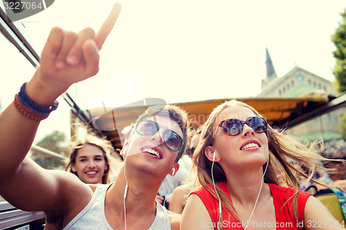 Image of smiling couple with earphones traveling by bus