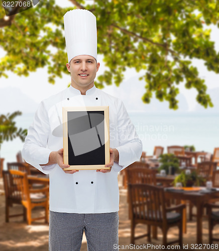 Image of happy male chef cook holding blank menu board