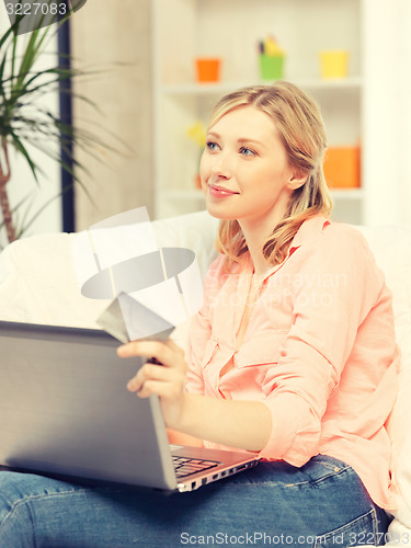 Image of happy woman with laptop computer and credit card