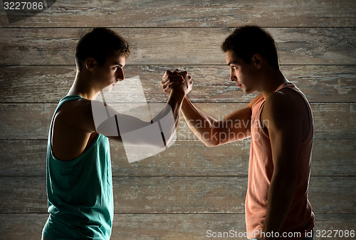 Image of two young men arm wrestling