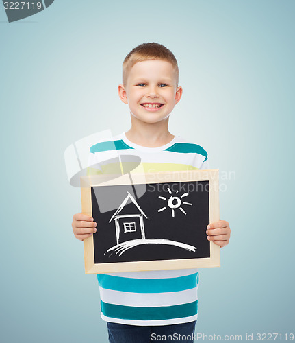 Image of happy little boy holding chalkboard with home