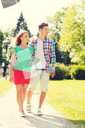 Image of smiling couple walking in park