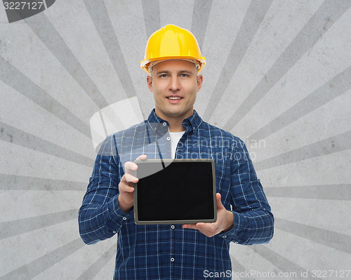 Image of smiling male builder in helmet with tablet pc