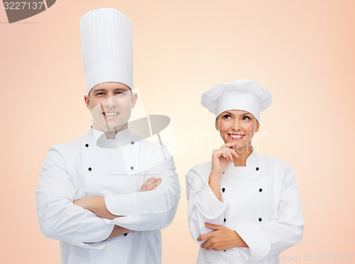 Image of happy chefs or cooks couple over beige background