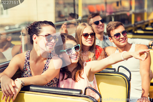 Image of group of smiling friends traveling by tour bus