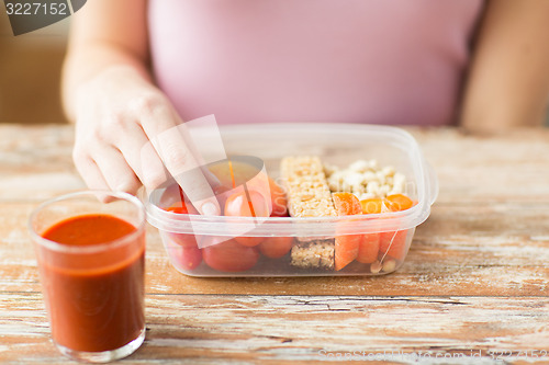 Image of close up of woman with vegetarian food in box