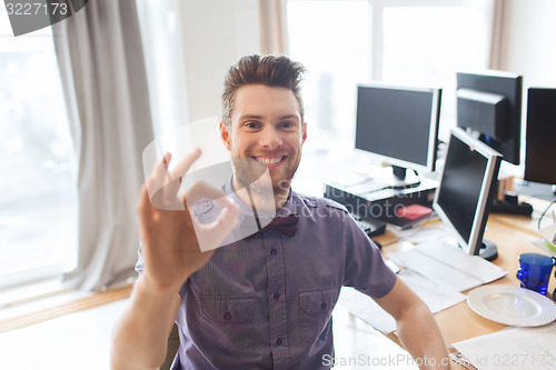 Image of happy creative male office worker showing ok sign