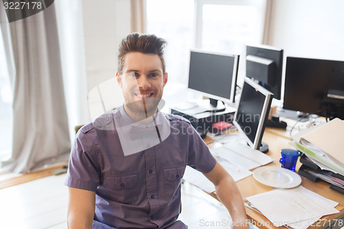 Image of happy creative male office worker with computers