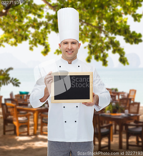 Image of happy male chef cook holding blank menu board