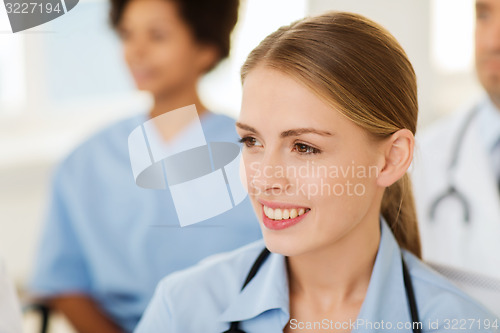 Image of happy doctor over group of medics at hospital